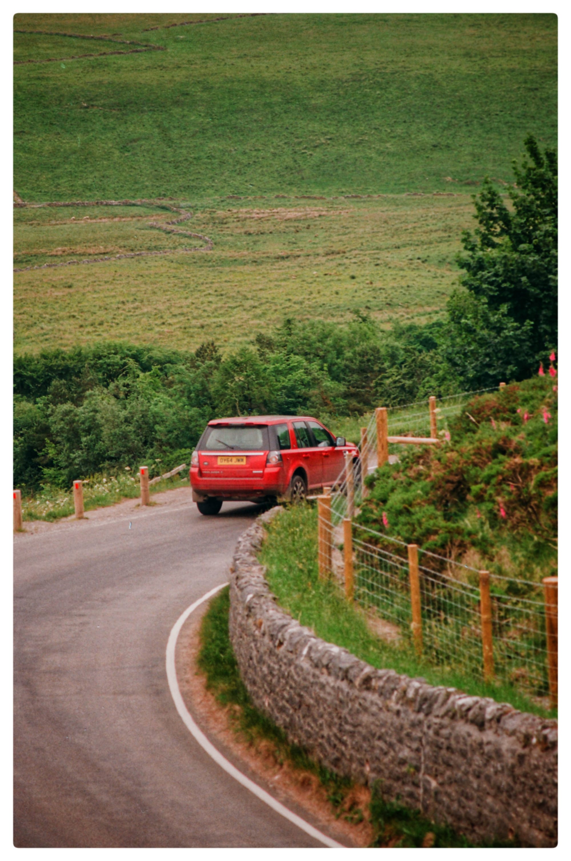 A film photo of a car driving through Mam Tor in the Peak District